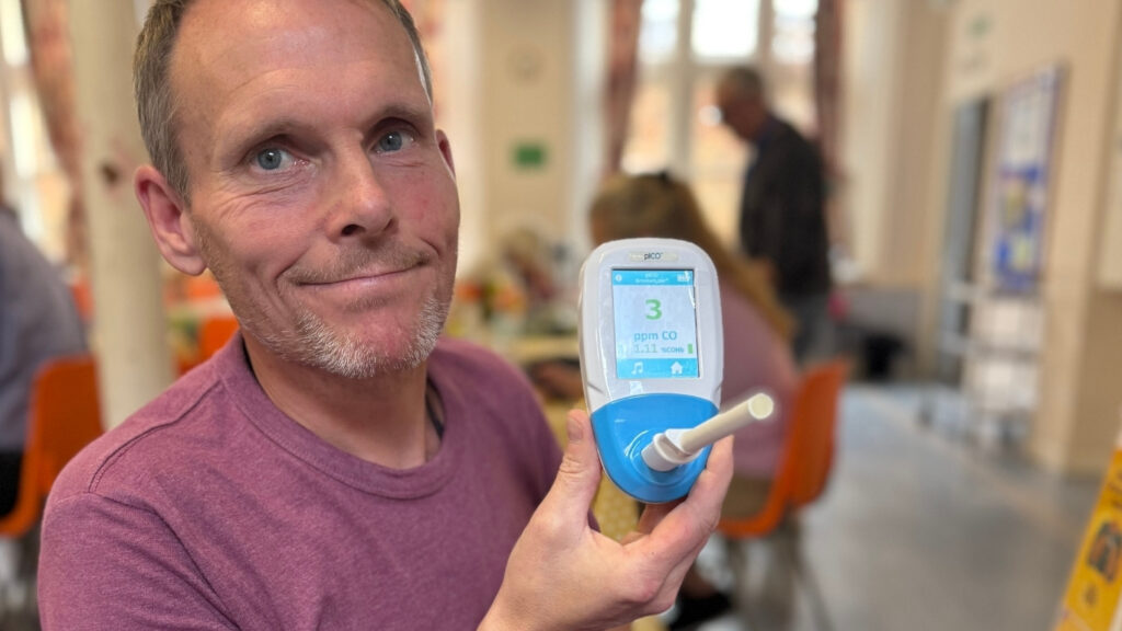 A man shows the results of his carbon monoxide breath test at Bury drop in