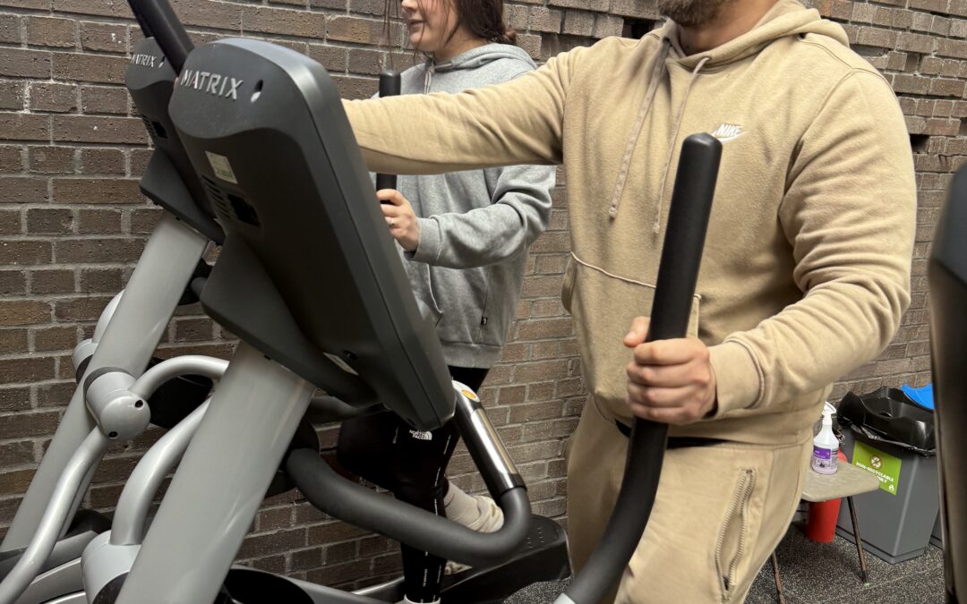man and woman exercise on a bike in a gym